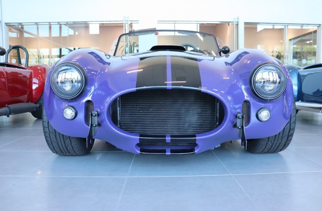 A purple roadster photographed from the front three-quarter